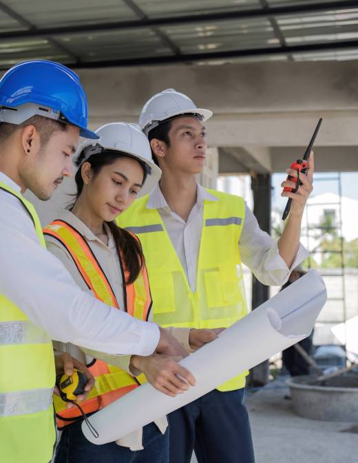 Civil engineer teams meeting working together wear worker helmets hardhat on construction site in modern city. Foreman industry project manager engineer teamwork. Asian industry professional team.
